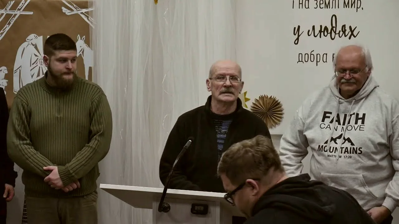 Троє чоловіків біля кафедри на вівторковому зібранні
